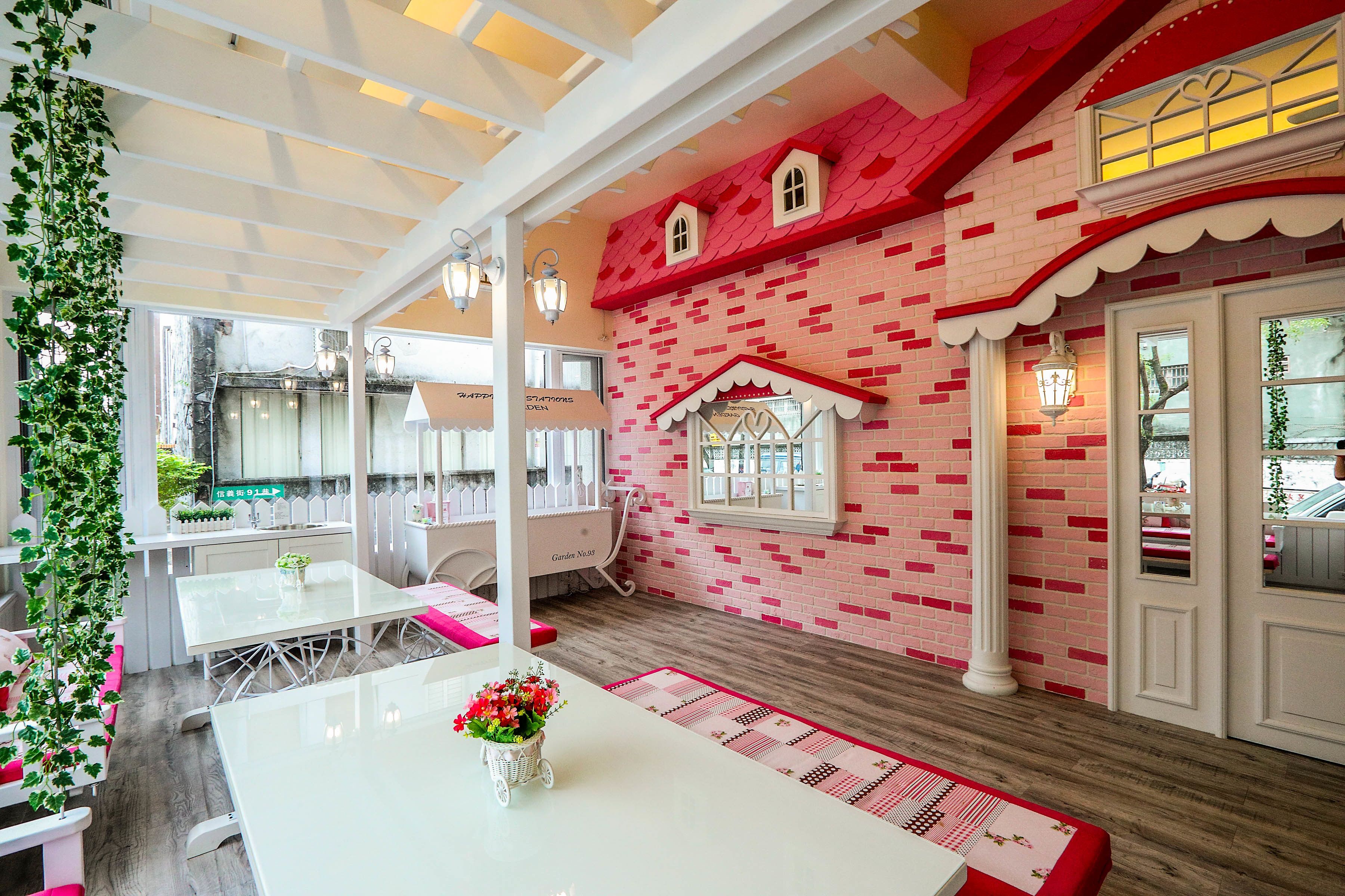 A cozy indoor space with a brick wall, a white table with a vase of flowers, and a bench.