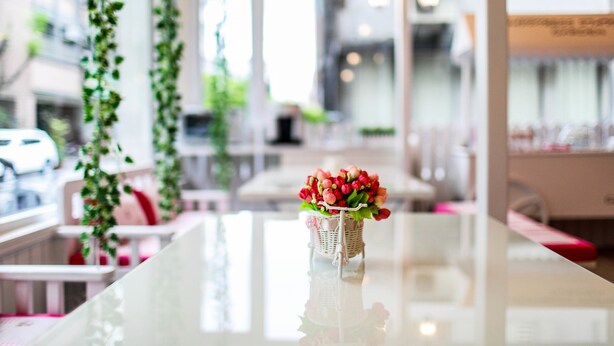 Een tafel met een bloemenmand, kamerplanten en een modern interieur met zitgedeeltes.