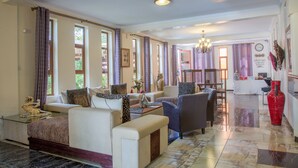 Amplia sala de estar con un conjunto de sofás, una mesa de centro y un comedor con sillas y una mesa.