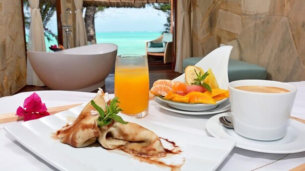 Desayuno con vistas al océano, que incluye una bañera, zumo de naranja, fruta y café.