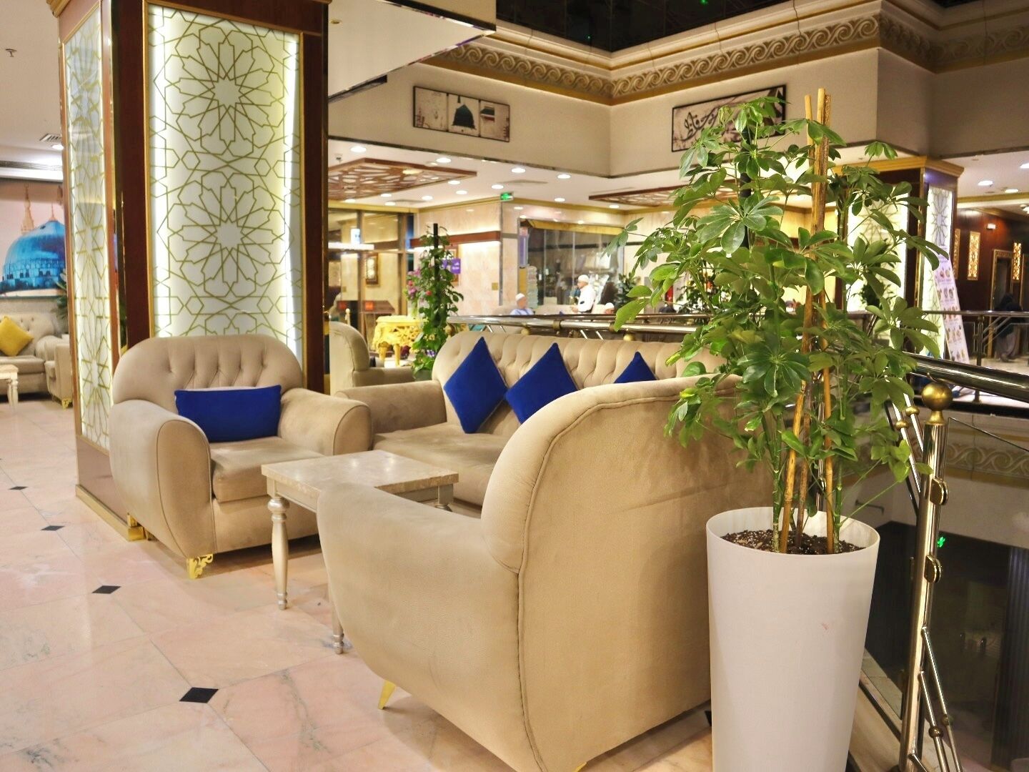 A lobby with sofas, a coffee table, and a potted plant.