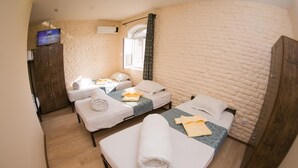 A hotel room with two beds, a wardrobe, a television, and a window with curtains. - Star Hotel Tashkent (Tashkent)