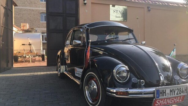 A vintage black car parked in front of a building with a sign reading "STAR hotel". - Star Hotel Tashkent (Tashkent)