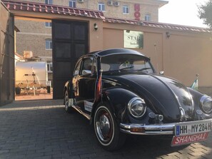 A vintage black car parked in front of a building with a sign reading "STAR hotel". - Star Hotel Tashkent (Tashkent)