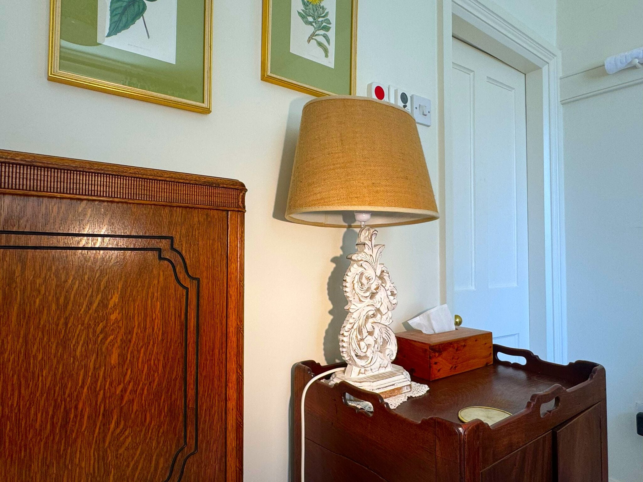 A wooden cabinet with a lamp and a tissue box on top.