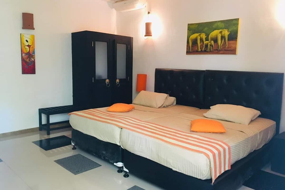 Ein Schlafzimmer mit Bett, Sitzbank, Kleiderschrank und einem Gemälde an der Wand.