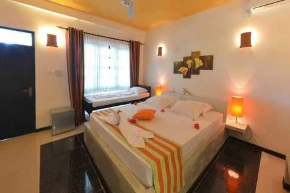 Ein Hotelzimmer mit Bett, Nachttischlampen, einem Fenster mit Vorhängen und einem Wandbild.