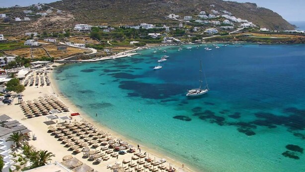 A coastal town with a beach, boats, and white buildings on a hillside. - Nalu Villa Mykonos (Mykonos)
