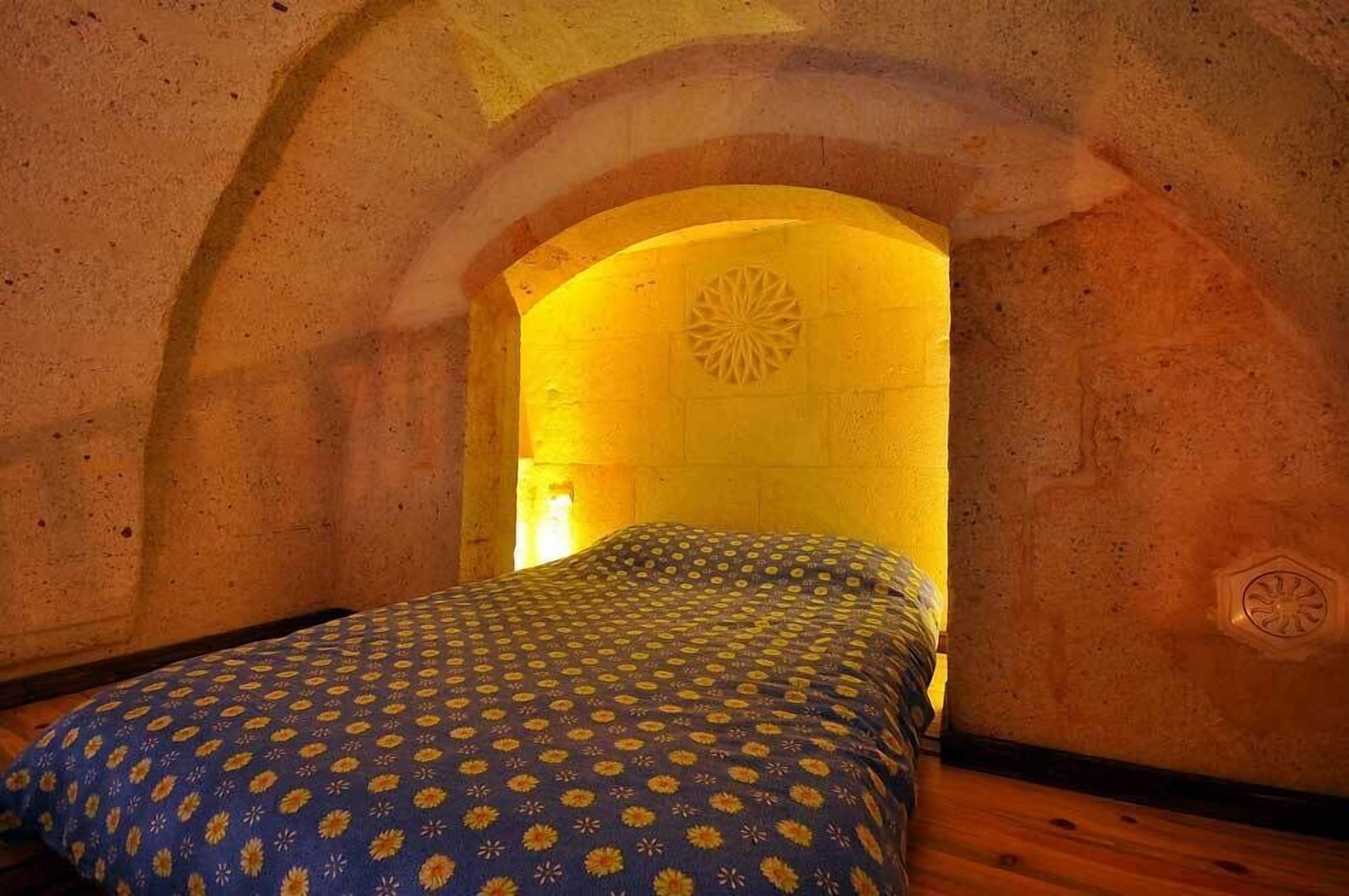 A room with a bed, an arched doorway, and a decorative wall pattern.