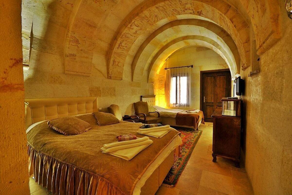 A bedroom with a large bed, a wooden dresser, and an arched ceiling.