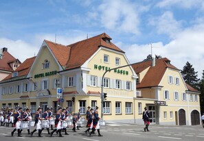 A hotel with a restaurant on the ground floor, a parking sign, and a marching band in front. - Hotel Hasen Kaufbeuren (Kaufbeuren)