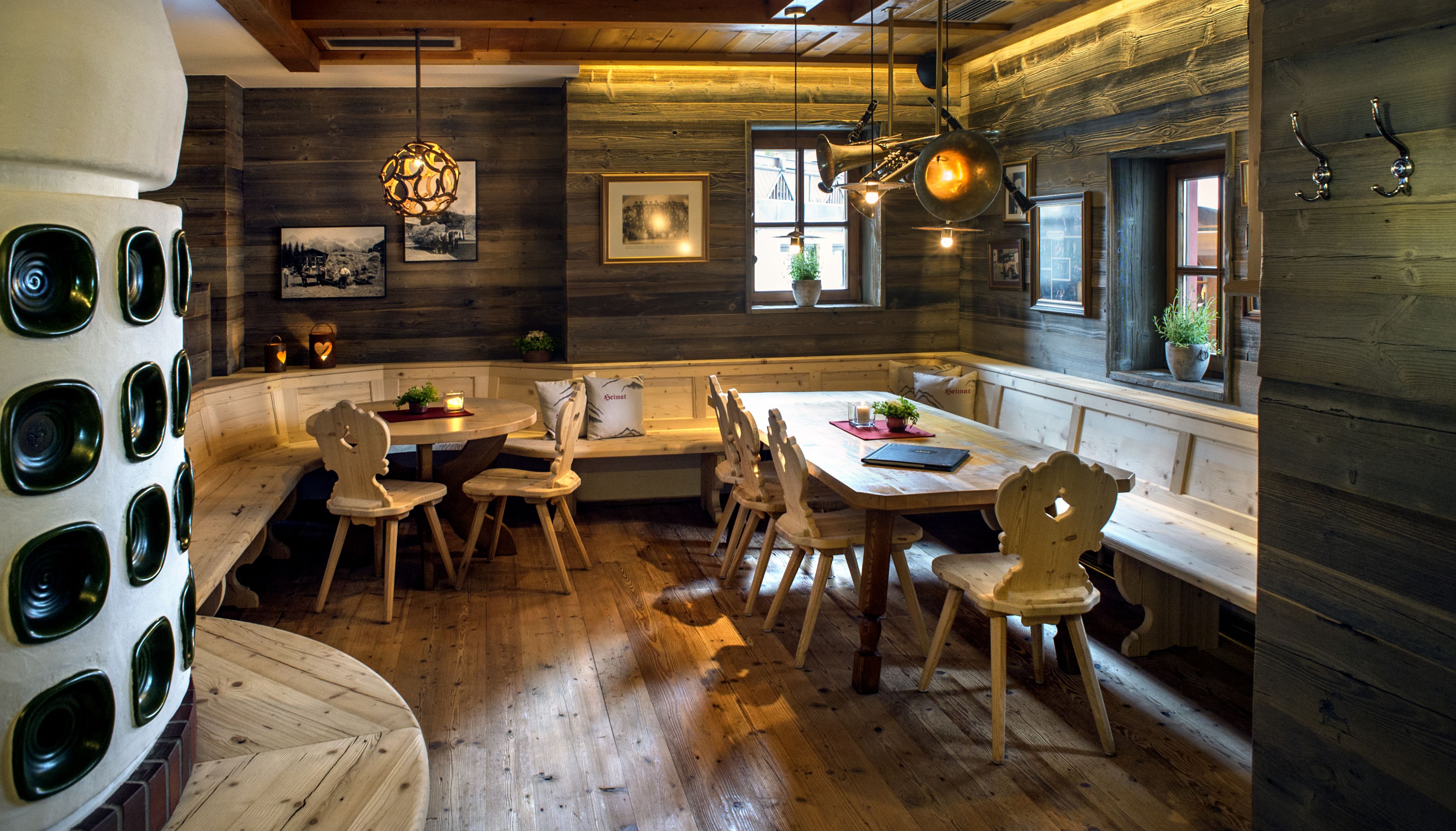 A cozy wooden interior with a round dining table, wooden chairs, and a bench.