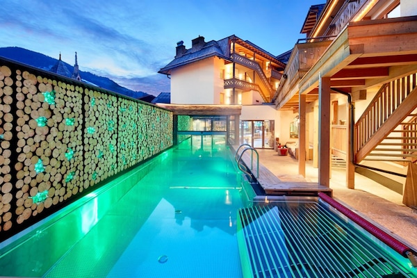 Alberca techada, alberca al aire libre y camastros