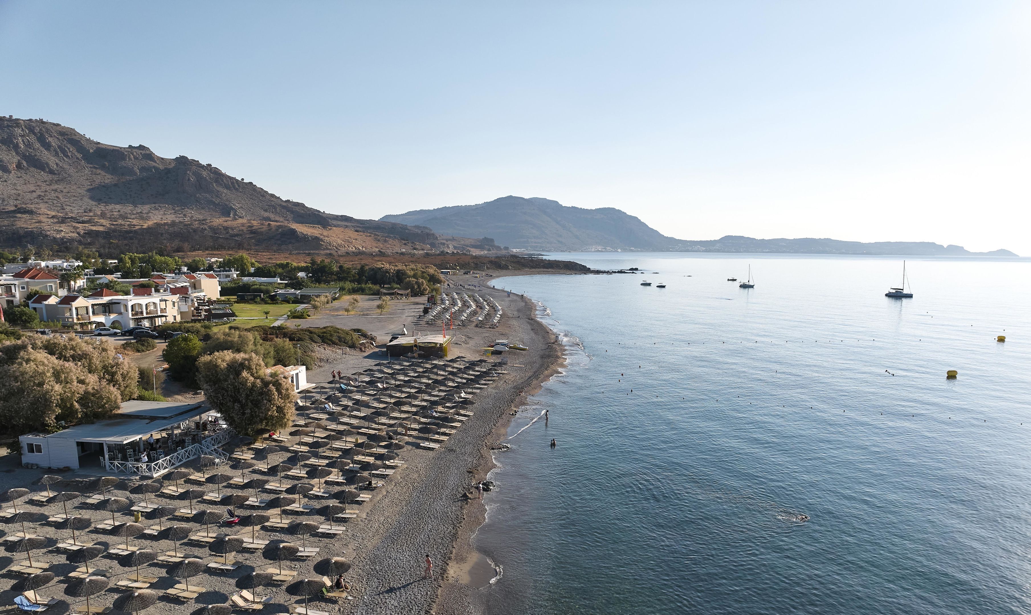 Una zona costera con playa, barcos y edificios.