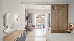Une chambre d’hôtel moderne équipée d’un lit, d’un bureau, d’une chaise, d’un grand miroir et offrant une vue sur l’espace piscine.