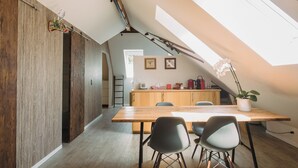 Una cucina moderna con un piano di lavoro in legno, un tavolo da pranzo con sedie e un lucernario.