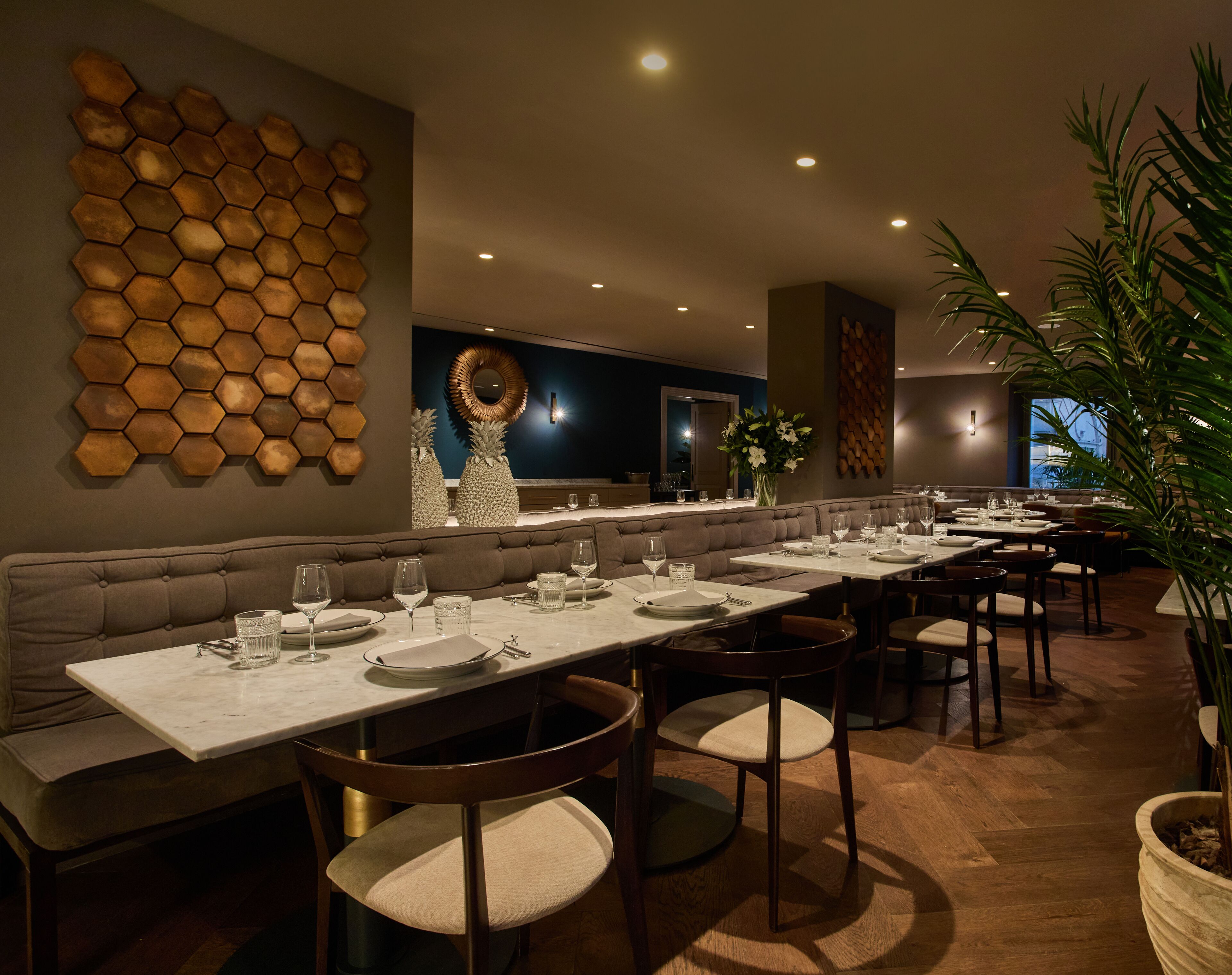 A restaurant with a long counter, multiple tables, and a variety of seating options including booths and chairs.