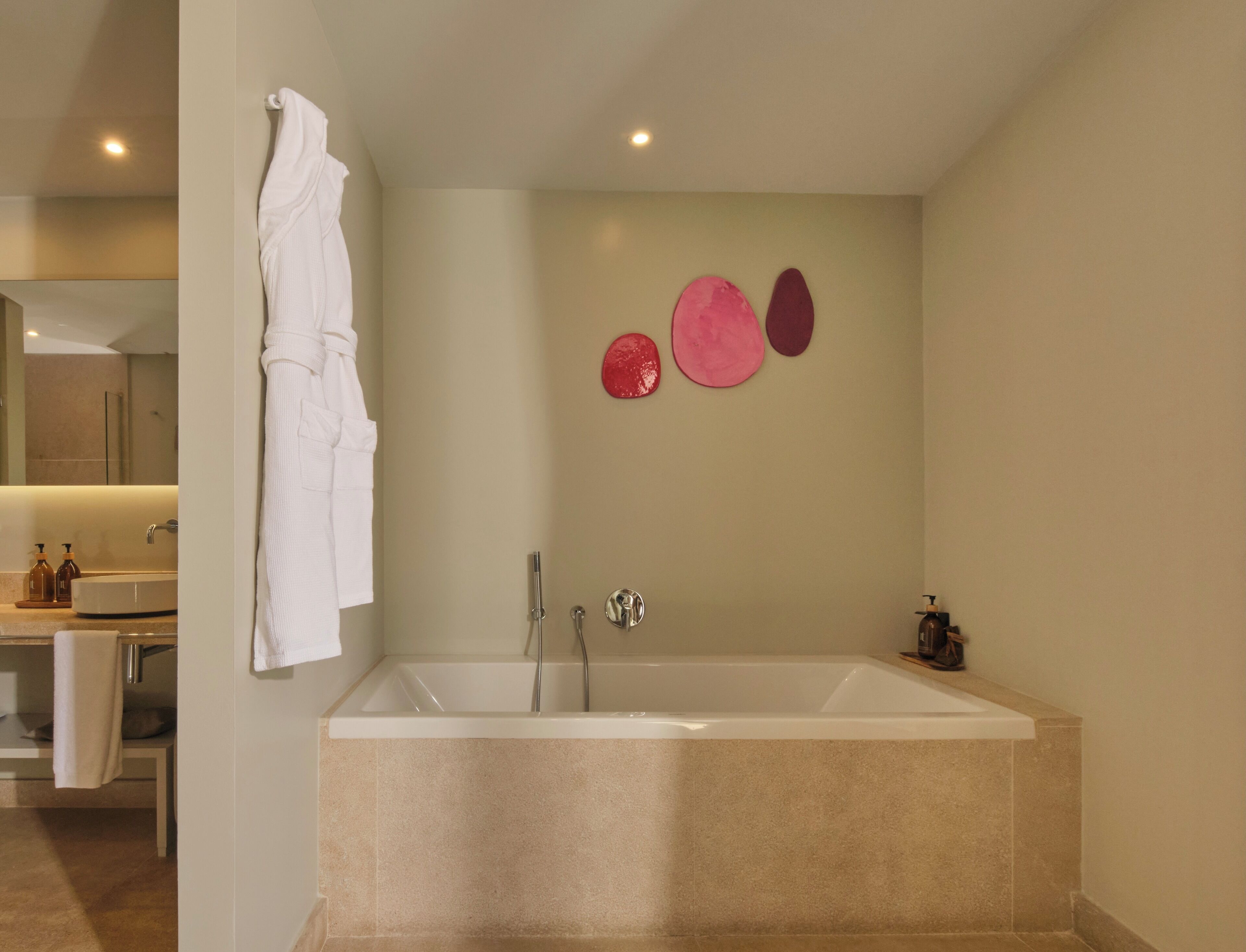 Een moderne badkamer met een groot bad, een spiegel en een handdoekrek.