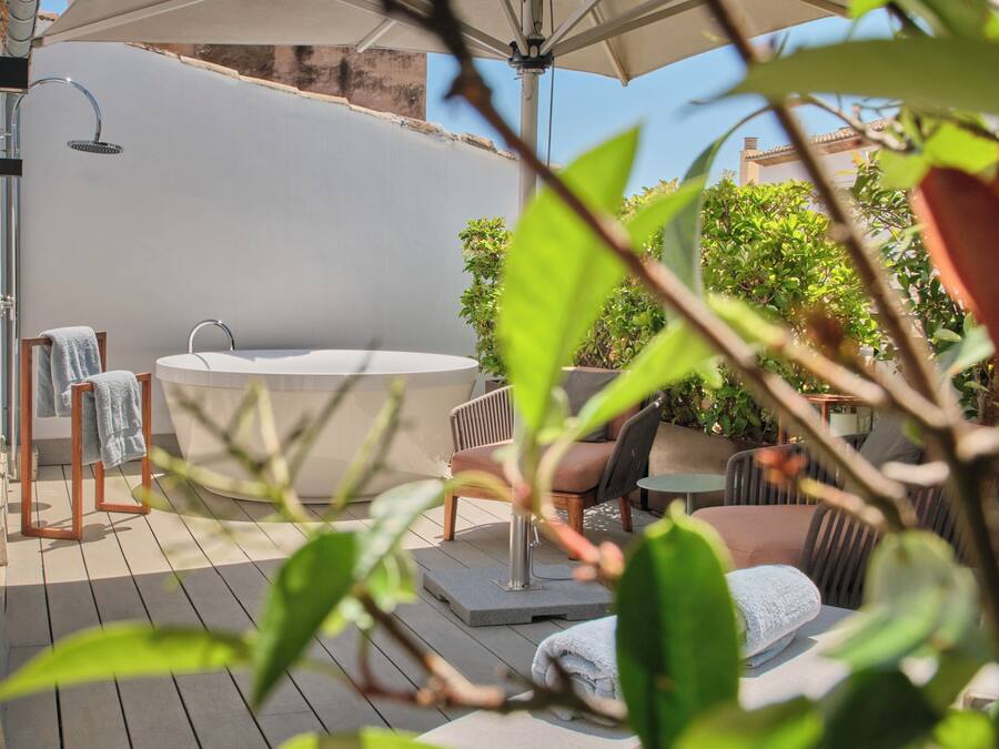 Terraza en la azotea con bañera de hidromasaje, zona de estar y ducha.