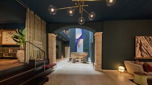 Un interior moderno con una escalera, una zona de estar y vistas a una pared azul y blanca.