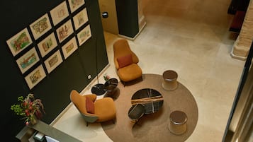 Un vestíbulo con una mesa de recepción, dos sofás, una mesa de centro y una pared con obras de arte enmarcadas.