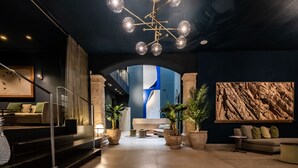 Un vestíbulo moderno con una escalera, zonas de estar y un cuadro abstracto grande.
