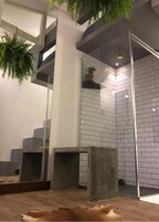 A modern interior with a staircase, concrete furniture, and a brick wall.