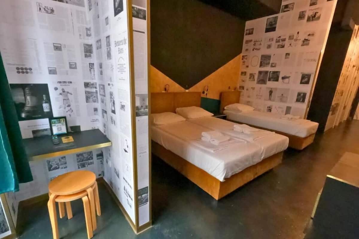 Ein Hotelzimmer mit zwei Betten, einem Schreibtisch und einem Stuhl.