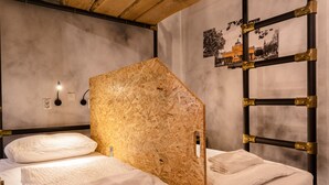 A room with a bed, a wooden partition, a wall-mounted ladder, and a framed picture. - Chillout Hostel Zagreb (Zagreb)