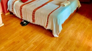 A bedroom with a bed, wooden wardrobe, and a small round table. - Family Cozy Bed & Breakfast (Addis Ababa)