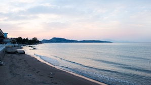A beach with a calm sea, a sandy shore, and a distant mountain range. - Paradise Beach Hotel (Zakynthos)