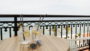 A table with two mason jars containing drinks, a pair of sunglasses, and a view of the ocean. - Paradise Beach Hotel (Zakynthos)