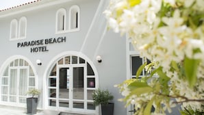The exterior of Paradise Beach Hotel with arched windows and a sign above the entrance. - Paradise Beach Hotel (Zakynthos)