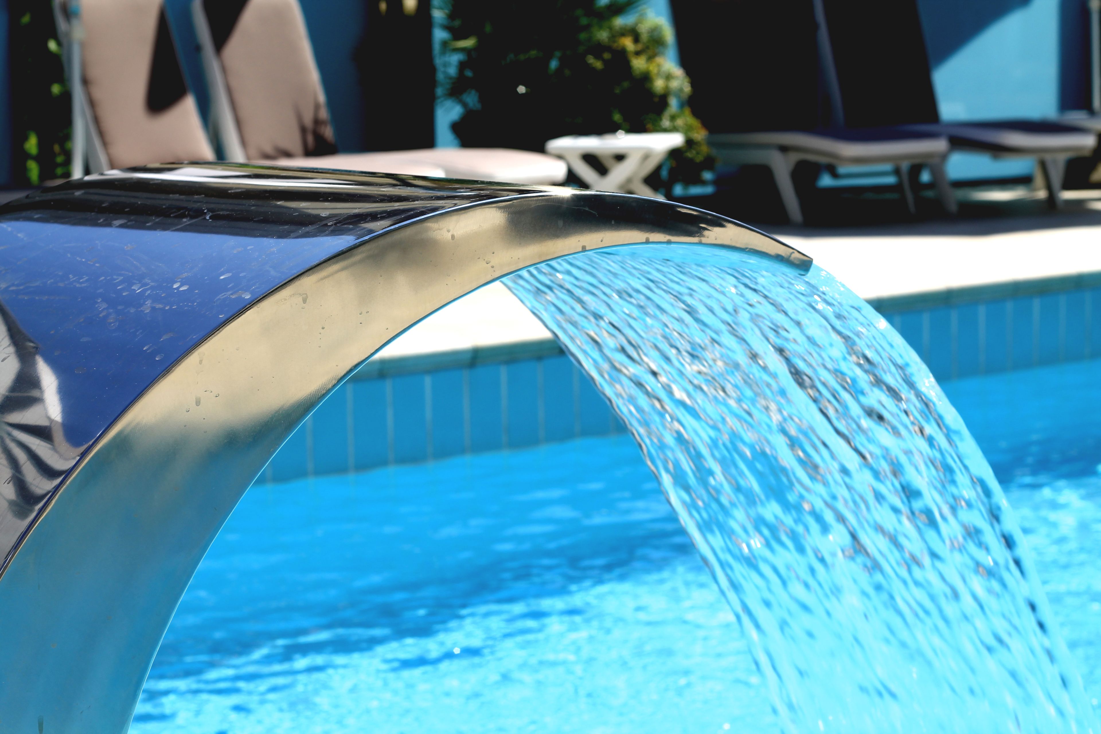 En swimmingpool med en vattenfontän eller ett annat vattendekorativt element.