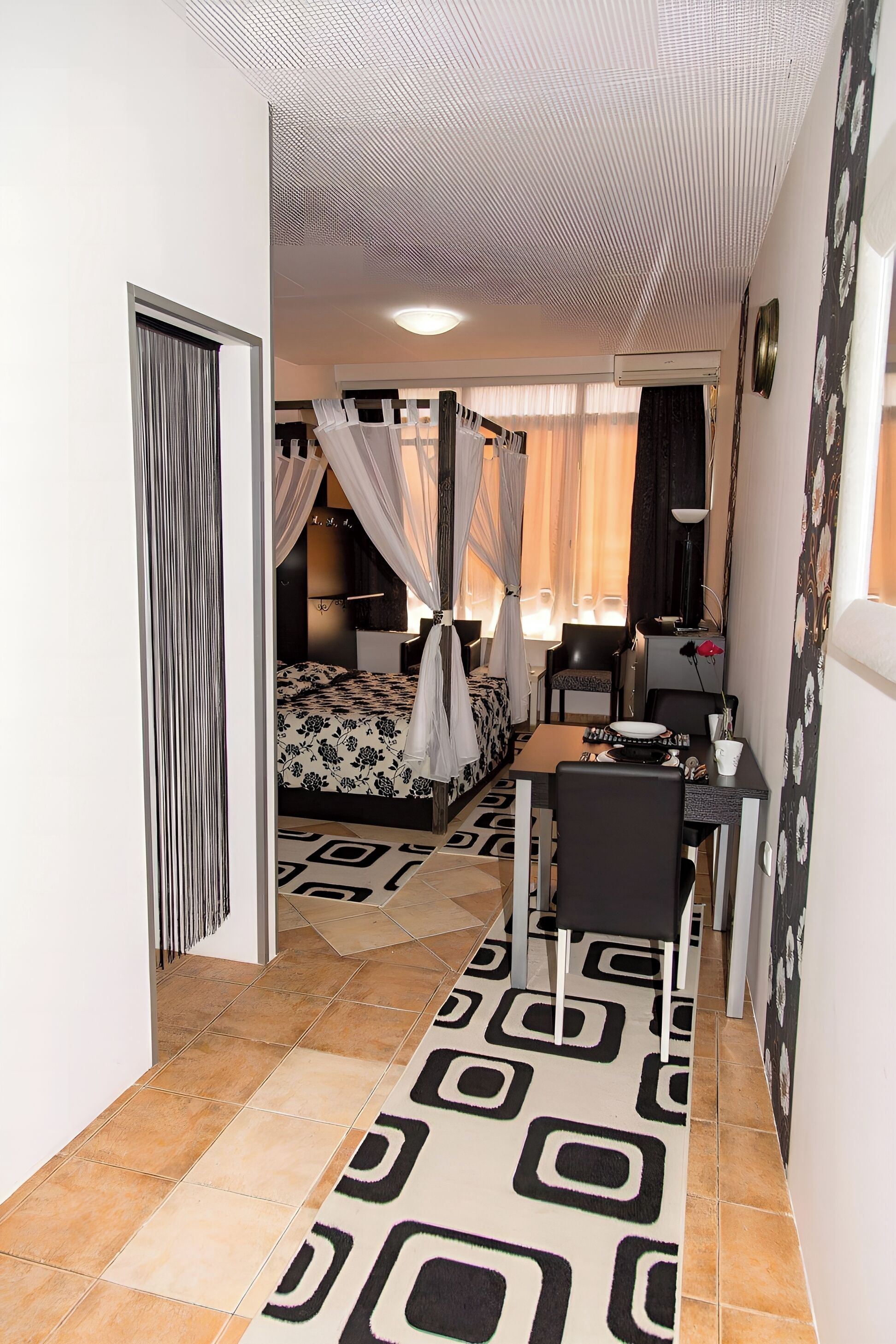 A bedroom with a bed, bedside table, and a desk with a chair.