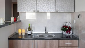A modern kitchen with a marble backsplash, wooden cabinets, and a black countertop.
