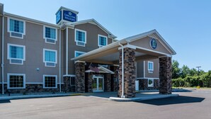 Een hotel met een overdekte ingang, meerdere ramen en een Amerikaanse vlag.