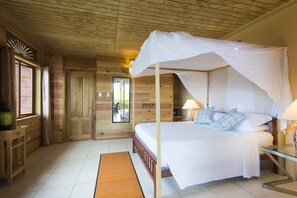 Une chambre à coucher dans un chalet en bois, avec un lit à baldaquin, une table de chevet en bois et un miroir au mur.