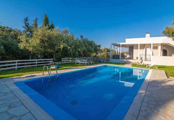 Una piscina al aire libre, sombrillas, tumbonas