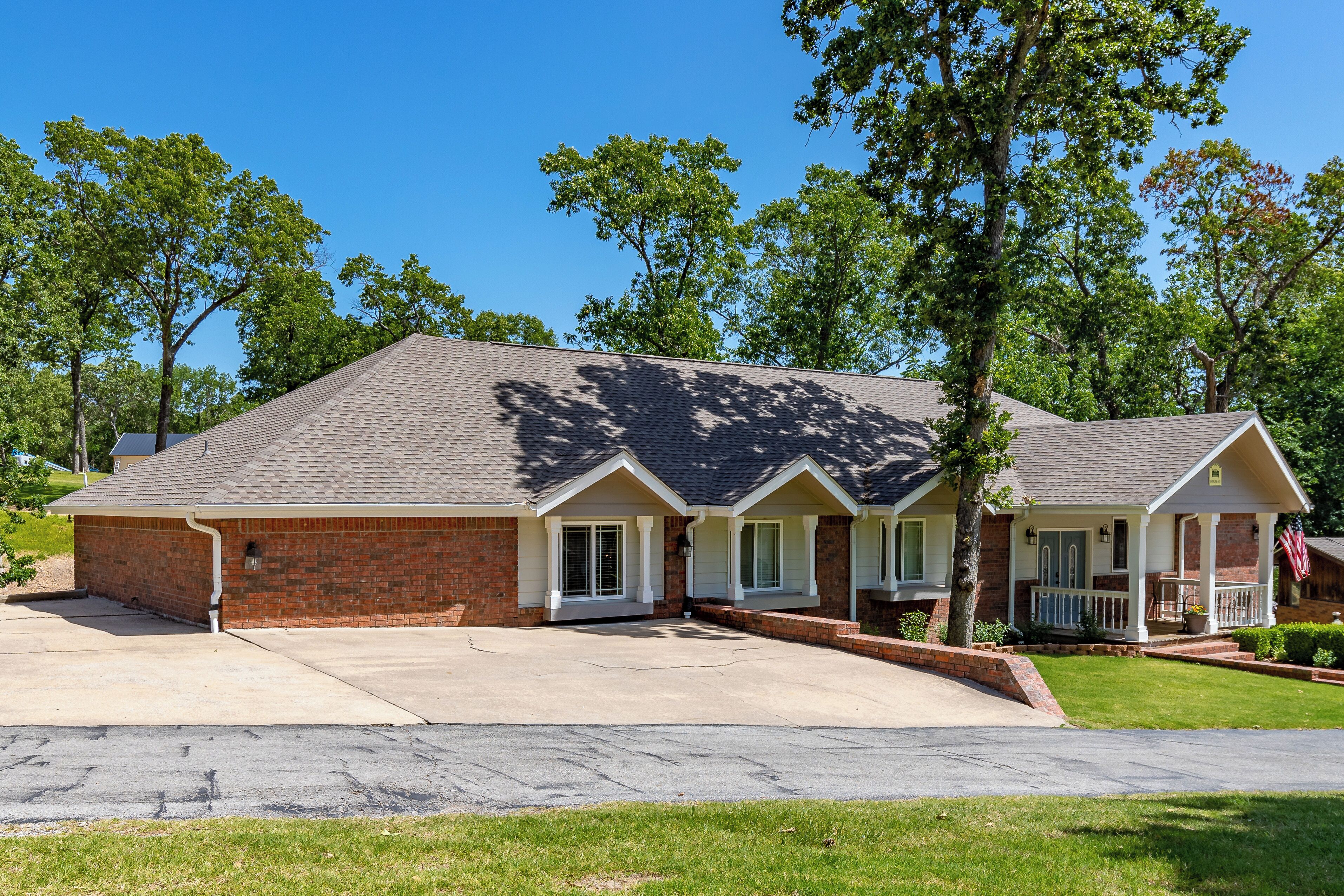 A two-story house with a brick facade, a front porch, and a driveway.