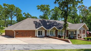 A two-story house with a brick facade, a front porch, and a driveway.
