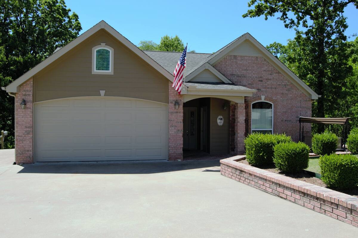 A single-story house with a garage, a small porch, and a brick exterior.