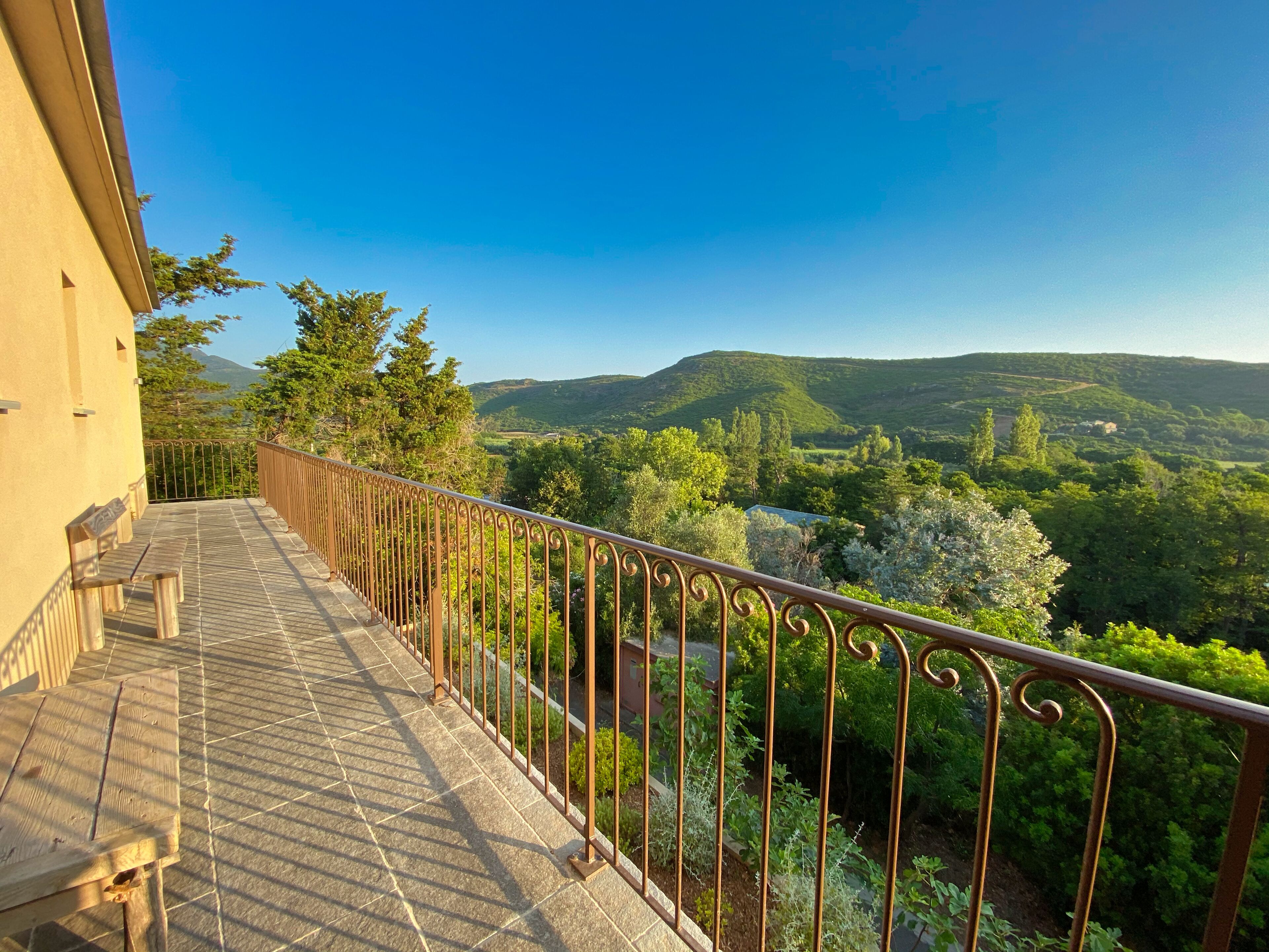 A balcony with a view of a mountainous landscape.