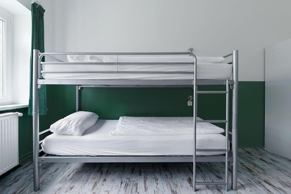 A bunk bed in a room with green walls and a white radiator. - Ballhaus Berlin Hostel (Berlin)