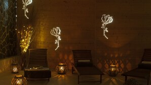 Un espace de détente avec des murs en bois, deux fauteuils et des éclairages décoratifs.