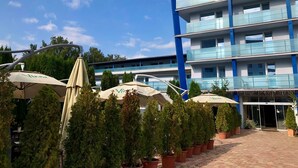 Un hôtel à plusieurs étages, doté d’une architecture moderne, avec des balcons et une entrée en verre.
