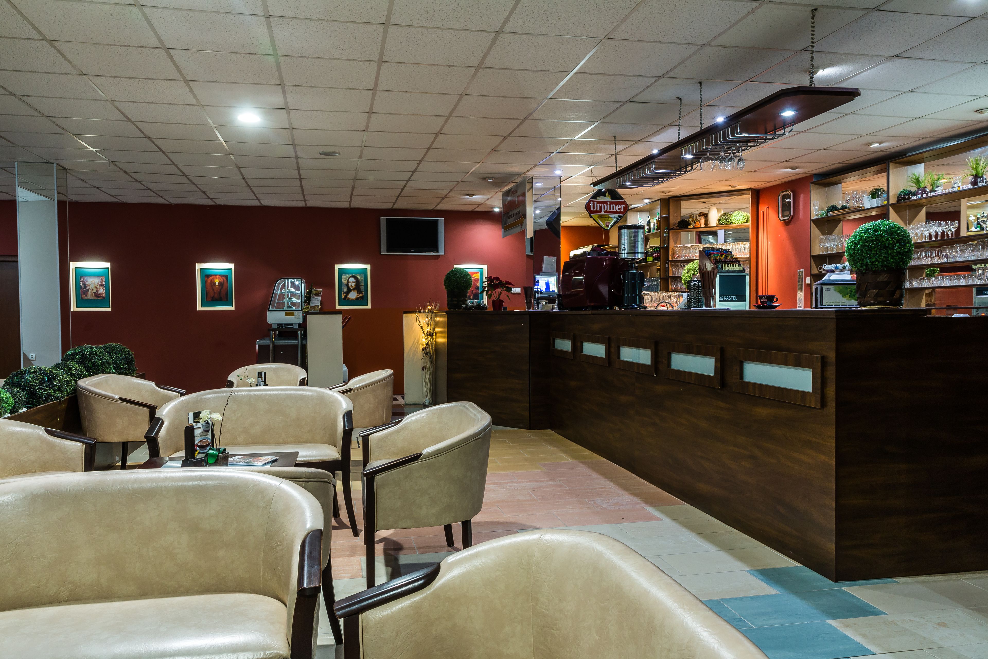 Ein Restaurantinneres mit Barbereich, Sitzgelegenheiten und einem Fernsehbildschirm.
