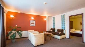 Una sala de estar moderna con sofá, sillones, una mesita de centro y una planta en maceta.
