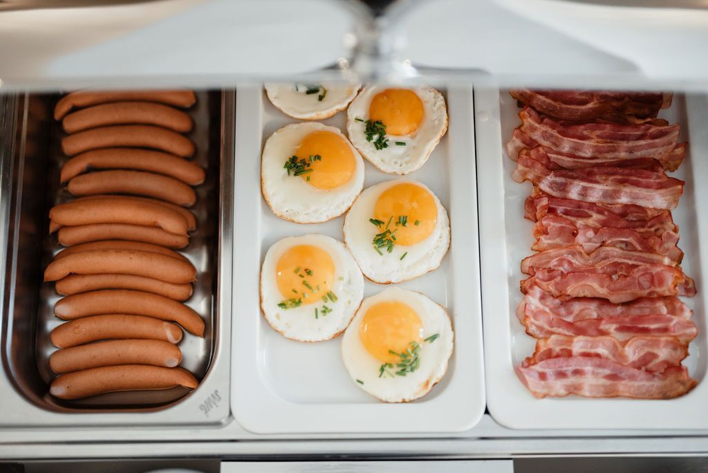 Un refrigerador con salchichas, huevos fritos y tocino.