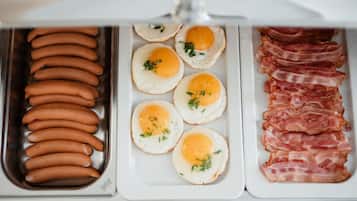 Un refrigerador con salchichas, huevos fritos y tocino.